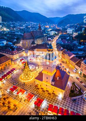 Brasov, Romania. Mercatino di Natale, splendide luci al crepuscolo, vista aerea con droni e piazza principale, destinazione turistica della Transilvania. Foto Stock
