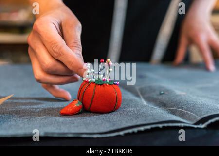 Stilista che mette le spille in un cuscinetto Foto Stock