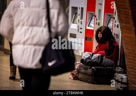 Colonia, Germania. 7 dicembre 2023. Una madre con due figli è bloccata nella stazione centrale di Colonia mentre si dirige verso la Germania settentrionale, sua figlia è seduta su una valigia. La German Train Drivers' Union (GDL) ha iniziato uno sciopero di allarme di 24 ore in serata. Credito: Christoph Reichwein/dpa/Alamy Live News Foto Stock