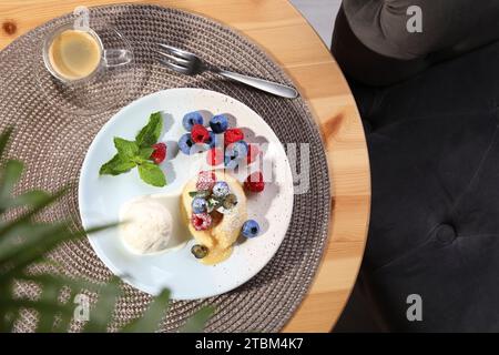 Delizioso fondente alla vaniglia servito con gelato e frutti di bosco sul tavolo, piatto Foto Stock