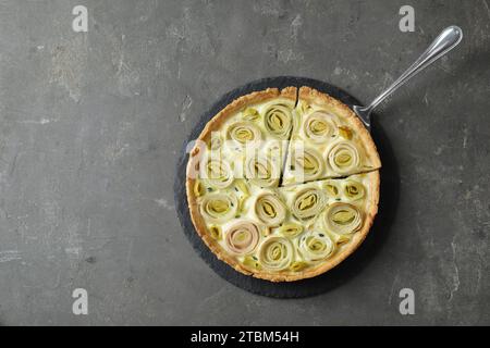 Gustosa torta di porri con torte su un tavolo ruvido scuro, vista dall'alto. Spazio per il testo Foto Stock