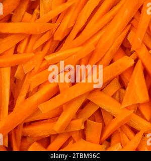 Carota arancia tagliata grossolanamente. Il processo di cottura del pilaf. Sfondo di verdure fresche e naturali Foto Stock