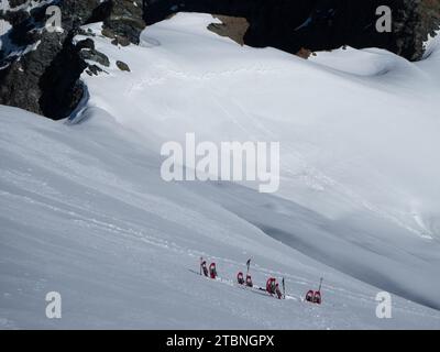 SaaS Fee, Svizzera - 16 giugno 2023: Deposito di racchette da neve sul ripido ghiacciaio per la salita alla vetta dello Strahlhorn Foto Stock