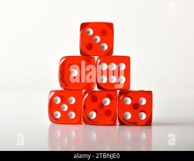 Set di dadi da gioco rossi trasparenti isolati su sfondo bianco che mostrano tutti i numeri possibili riflessi sulla base. Vista frontale. Foto Stock