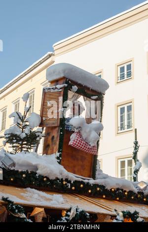 Rosenheim, Germania - 3 dicembre 2023: Stare con Frau Holle sul tetto scuotendo i letti al mercatino di Natale di Rosenheim Foto Stock