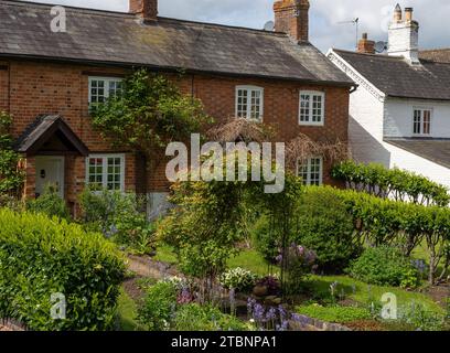 Fila di cottage terrazzati con giardini ben forniti, Abthorpe Village, Northamptonshire, Regno Unito Foto Stock