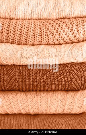 Pullover da donna caldo e accogliente. Abiti caldi autunnali o invernali. Tonalità dell'immagine con colori alla moda dell'anno 2024 Peach Fuzz. Primo piano. Foto Stock