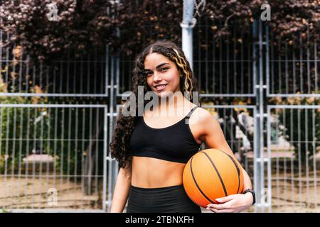 atleta con il basket in mano su un campo Foto Stock