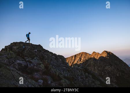 Un escursionista di sesso maschile solitario cammina lungo la cresta del coltello al tramonto, Katahdin Foto Stock