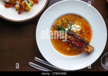 zuppa di verdure con costolette di manzo in un piatto Foto Stock