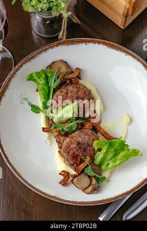 polpette fritte su un piatto con patate e verdure Foto Stock