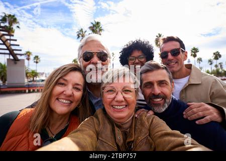Gruppo multirazziale di persone mature che scattano un selfie insieme durante il viaggio con la famiglia e gli amici. Foto Stock