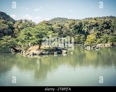 Un idilliaco scenario all'aperto con un pittoresco parco e un tranquillo laghetto situato in una soleggiata area rurale Foto Stock