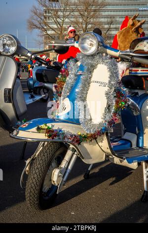 Lambretta decorata a Natale, i membri del club Vespa RheinSchalter Koeln vestiti come Santas si riuniscono sul Deutzer Werft prima di un giro Foto Stock