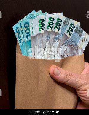 Un primo piano di busta con banconote brasiliane del Reais. Foto Stock