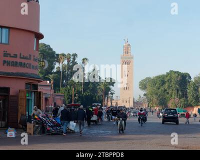 Strada trafficata con la moschea Koutoubia alle spalle a Marrakech, alias Marrakech, Marocco, 8 dicembre 2023 Foto Stock