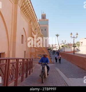 Uomo che indossa un cappello e guida in moto di fronte alla Moschea della Kasbah di Marrakech, alias Marrakech, Marocco, 8 dicembre 2023 Foto Stock