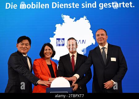 8 dicembre 2023, Renania-Palatinato, Montabaur: Hiroshi Mikitani (l-r), CEO di Rakuten, Daniela Schmitt (FDP), Ministro dell'economia, dei trasporti, dell'agricoltura e della viticoltura dello stato della Renania-Palatinato, Volker Wissing (FDP), Ministro federale dei trasporti, e Ralph Dommermuth, CEO di 1&1, premere simbolicamente un pulsante di avvio. Il provider di telecomunicazioni 1&1 prevede di lanciare ufficialmente i suoi servizi mobili venerdì pomeriggio. Alla fine di settembre, 60 siti di antenne erano pronti per le connessioni telefoniche; 200 saranno attivati entro l'inizio del 2024. Foto: Federico Gambarini Foto Stock