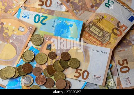 Banconote e monete in euro sparse sul tavolo come sfondo Foto Stock