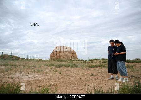 (231208) -- YANCHI, 8 dicembre 2023 (Xinhua) -- Chen Jing (R) documenta una torre di fumo dell'antica grande Muraglia attraverso un drone nella contea di Yanchi, regione autonoma Ningxia Hui della Cina nord-occidentale, 17 agosto 2023. La contea di Yanchi, conosciuta come "Museo della grande Muraglia", ospita una sezione di 259 km dell'antica grande Muraglia. Chen Jing e suo marito Gao Wandong si sono impegnati a documentare la sezione Yanchi dell'antico grande muro dal 2008. Finora, hanno percorso oltre 100.000 km e scattato più di 100.000 foto durante l'esplorazione. La coppia ha anche pubblicato un album fotografico e lanciato Foto Stock