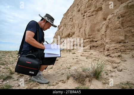 (231208) -- YANCHI, 8 dicembre 2023 (Xinhua) -- Gao Wandong documenta una torre di fumo dell'antica grande Muraglia nel suo tronco nella contea di Yanchi, regione autonoma Ningxia Hui della Cina nord-occidentale, 17 agosto 2023. La contea di Yanchi, conosciuta come "Museo della grande Muraglia", ospita una sezione di 259 km dell'antica grande Muraglia. Chen Jing e suo marito Gao Wandong si sono impegnati a documentare la sezione Yanchi dell'antico grande muro dal 2008. Finora, hanno percorso oltre 100.000 km e scattato più di 100.000 foto durante l'esplorazione. La coppia ha anche pubblicato un album fotografico e lanciato Am Foto Stock