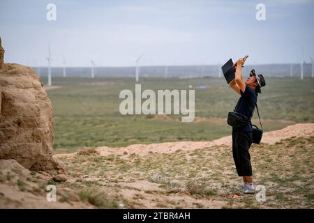 (231208) -- YANCHI, 8 dicembre 2023 (Xinhua) -- Gao Wandong documenta una torre di fumo dell'antica grande Muraglia tramite un telefono nella contea di Yanchi, regione autonoma Ningxia Hui della Cina nord-occidentale, 17 agosto 2023. La contea di Yanchi, conosciuta come "Museo della grande Muraglia", ospita una sezione di 259 km dell'antica grande Muraglia. Chen Jing e suo marito Gao Wandong si sono impegnati a documentare la sezione Yanchi dell'antico grande muro dal 2008. Finora, hanno percorso oltre 100.000 km e scattato più di 100.000 foto durante l'esplorazione. La coppia ha anche pubblicato un album fotografico e ha lanciato un Foto Stock