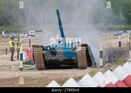 ALABINO, RUSSIA - 19 AGOSTO 2022: Il serbatoio T-72B3 di colore blu supera l'ostacolo "Ditch". Frammento di biathlon. Giochi di guerra internazionali Foto Stock