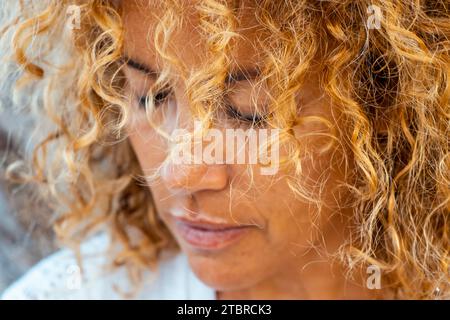 Ritratto ravvicinato di donna adulta triste e solitaria con occhi chiusi e capelli ricci. Un concetto infelice di stile di vita femminile maturo all'aperto. Signora delusa con una triste espressione in faccia. Salute mentale Foto Stock