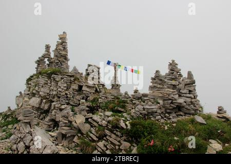 Bergmandl con bandiere di preghiera tibetane in densa svegliarsi sulla strada per la cima dello Schafreuter (2,102 m) nel Karwendelgebirge, Lenggries, Tölzer la Foto Stock