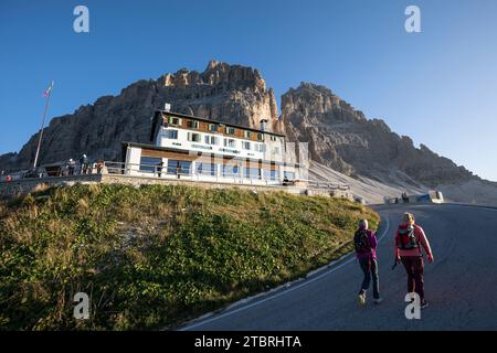 Escursionisti di fronte al Rifugio Auronzo (2320 m), ai piedi meridionali delle tre Cime, con il picco occidentale e il grande picco Foto Stock