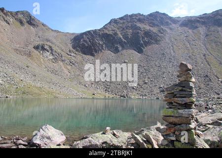 Hundstaller SEE (2289 m), Steinmandl in primo piano, sullo sfondo il Tempio di Apollo, escursione nei pressi di Inzing, Innsbruck Land, Stubai Alps, Tirolo, Austria Foto Stock