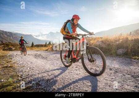 Italia, Veneto, provincia di Belluno, attività outdoor per famiglie, madre e figlia adolescente su strada sterrata in sella alle rispettive e-bike Foto Stock