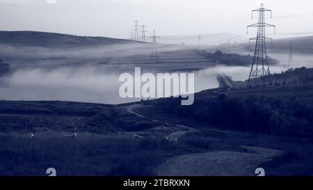 Clowbridge Dunnockshaw all'alba Pendle Hill è visibile sullo sfondo la nebbia del mattino presto dal serbatoio copre parzialmente la strada rialzata che conduce l'occhio. Foto Stock