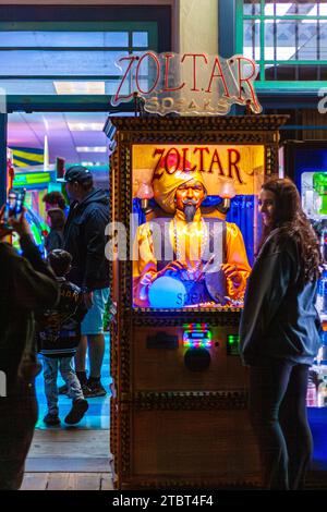 Una giovane donna in posa con Zoltar, una macchina da gioco arcade per raccontare la fortuna Foto Stock