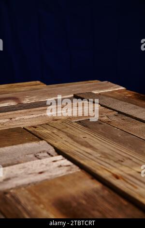 Superficie in legno resistente agli agenti atmosferici con fascino rustico e primo piano sullo sfondo blu scuro Foto Stock