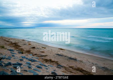 Serena alba sul paesaggio roccioso sfocato del lago Michigan Foto Stock