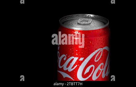 Chisinau, Moldova 4 dicembre 2023: Lattina di alluminio di Coca-Cola con gocce d'acqua isolate su sfondo nero Foto Stock