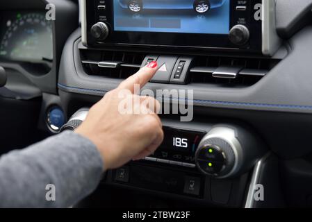 Pulsante di avvertimento di emergenza auto triangolare rosso femmina premuto Foto Stock