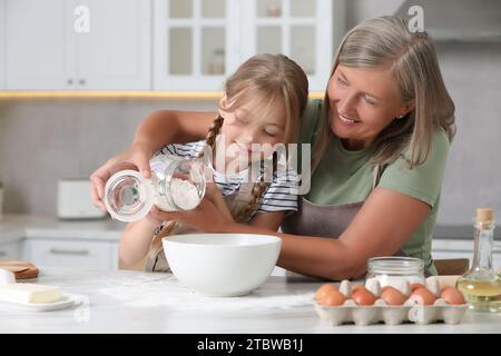 Nonna felice con sua nipote che cucinava insieme in cucina Foto Stock