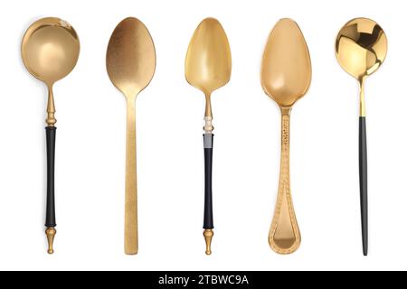 Diversi cucchiai dorati su sfondo bianco Foto Stock