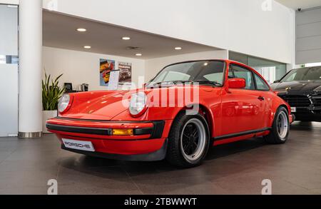 Una foto di una Porsche 911 Carrera 3,0 rossa all'interno di una concessionaria Foto Stock