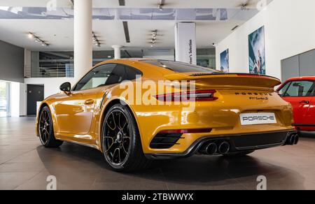 Immagine di una Porsche 911 Turbo S arancione all'interno di una concessionaria Foto Stock