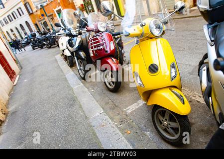 Set di scooter moderni e vintage parcheggiati per le strade di Roma Foto Stock