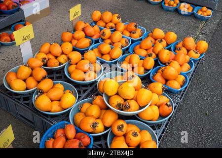 I persimmoni vendevano in cesti in un mercato locale in Giappone. Foto Stock