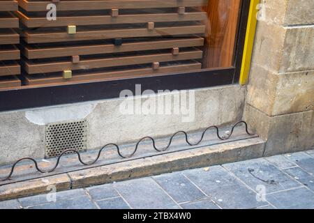 il design ostile in acciaio montato sulla facciata del negozio impedisce ai senzatetto di sedersi Foto Stock