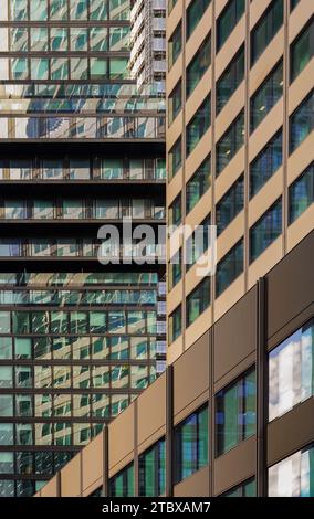 Alto edificio nel quartiere bancario con riflessi nelle facciate di vetro di Neue Mainzer Straße. Il canyon di strada fiancheggiato da grattacieli su entrambi i lati. Foto Stock