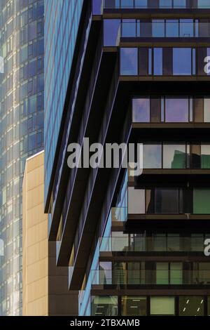 Alto edificio nel quartiere bancario con riflessi nelle facciate di vetro di Neue Mainzer Straße. Il canyon di strada fiancheggiato da grattacieli su entrambi i lati. Foto Stock