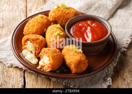 Polpette di riso italiano ripiene di mozzarella e primi piani fritti sul piatto sul tavolo. Orizzontale Foto Stock