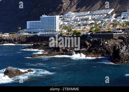 Los Gigantes costa spettacolare a sud di Tenerife con una piscina naturale di acqua di mare e il villaggio di Los Gigantes e l'hotel sostenuto da impressionanti scogliere. Foto Stock