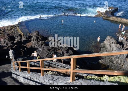 La piscina marina naturale di Puerto de Santiago Tenerife vicino a Los Gigantes, con i vacanzieri che si godono una nuotata. Foto Stock